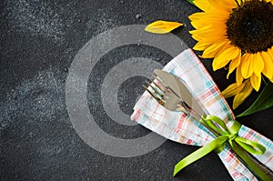 Autumn table place setting, cutlery with napkin and sunflower