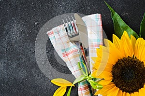 Autumn table place setting, cutlery with napkin and sunflower