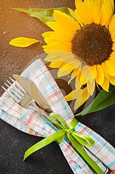 Autumn table place setting, cutlery with napkin and sunflower