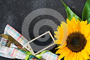 Autumn table place setting with empty tag, cutlery with napkin and sunflower