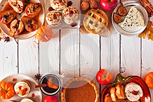 Autumn table scene double border of pies, appetizers and desserts. Top view over a white wood background with copy space.