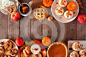 Autumn table scene double border of pies, appetizers and desserts. Top view over a wood background with copy space.