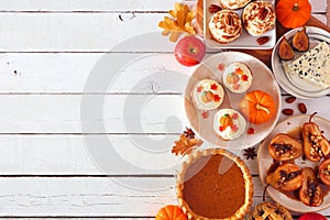 Autumn table scene side border of pies, appetizers and desserts. Top view over a white wood background with copy space.