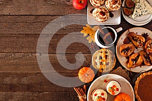 Autumn table scene side border of pies, appetizers and desserts. Top view over a wood background with copy space.