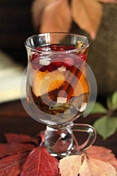 Autumn tea with lemon, spices in glass cup closeup