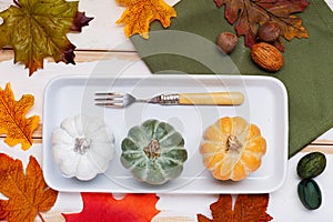 Autumn Thanksgiving table setting for dinner with plate,fork decorated pumpkins. Top view