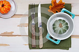 Autumn Thanksgiving table setting for dinner with plate, knife, fork decorated pumpkins. Top view