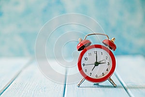 Autumn time change concept - red alarm clock on wood background