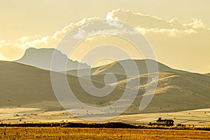 Autumn time, yellowed plains, mountain view. A solitary house in the field. Autumn scene. arid lands