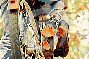 Autumn tree leaves and vinrage bike. Fall concept. Riding the bicycle in the park. Active people. Outdoors. Enjoying