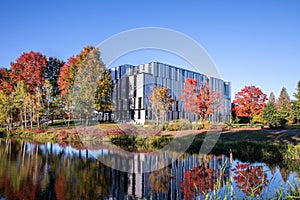 Autumn trees with red, green and yellow reflect in a park pond. Fall theme