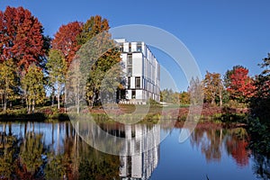 Autumn trees with red, green and yellow reflect in a park pond. Fall theme