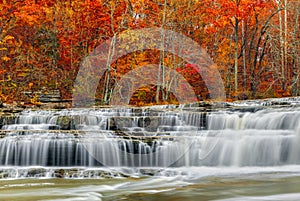 Whitewater vierte sobre rocas salientes en Indianas Superior de la Catarata Cae con hermoso, colorido follaje de otoño.