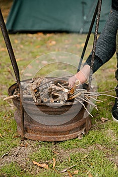 Autumn vacation concept. Man hiker make fire in forest