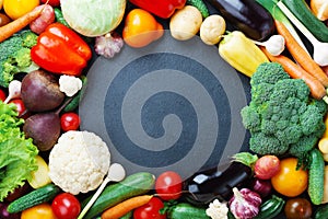 Autumn vegetables and crops on black kitchen table top view with copy space for text. Healthy and organic food background.