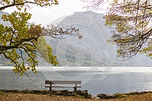 autumn view of lake, trees and bench in Toscana Park, Gmunden