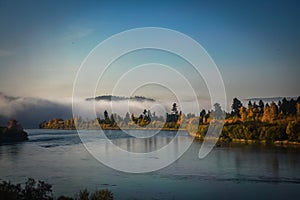 autumn view of the river and trees with fog