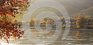 Autumn view of small austrian village on a river bank