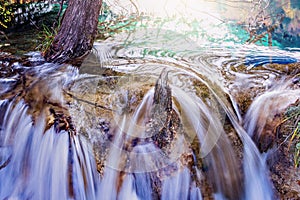 Autumn view of the small waterfall with pure water at sunset.