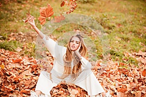 Autumn vogue. Young stylish hipster girl wearing modern dress in urban park smiling happy. Caucasian female model. Fall