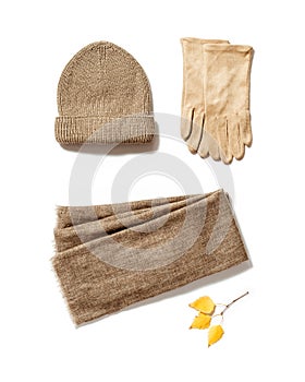 Autumn warm clothes, knitted hat, wool scarf and suede gloves with craft paper for copy space. Warm wear