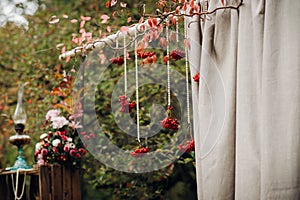 Autumn wedding ceremony on the street on the green lawn.Decor with arches of fresh flowers for the ceremony