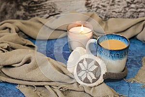 Autumn and winter background with candle, scarf, mug of cocoa, coffee or hot chocolate. Concept of warm cozy home