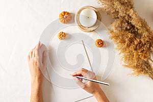 Autumn and winter checklist goals and woman hands, candle and dry pampas grass