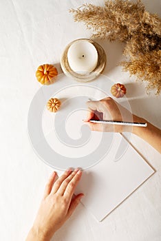 Autumn and winter checklist goals and woman hands, candle and dry pampas grass