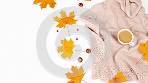 Autumn or winter composition. A cup of coffee, a gift, dry autumn leaves, a beige sweater on a white background. Flat lay, top