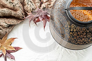 Autumn, winter composition.Lantern, maple leaves and plaid on white linen background.Winter wedding, tanksgiving concept.Top view