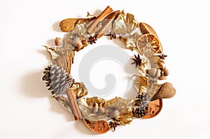 Autumn Winter composition. Wreath made of leaves, cone, cinnamon, cotton and acorns on white background