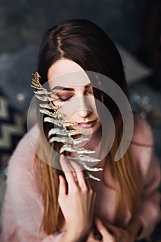 Autumn, Winter portrait: Young sad woman dressed in a warm woolen cardigan posing inside.