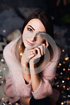 Autumn, Winter portrait: Young sad woman dressed in a warm woolen cardigan posing inside.