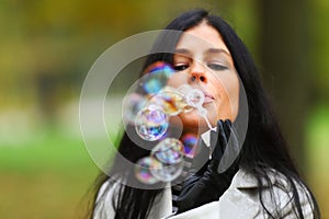 Autumn woman blow bubbles