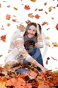 Autumn woman in a colorful pile of leaves