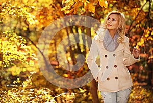 Autumn Woman. Fall. Blonde Beautiful Girl with Yellow Leaves