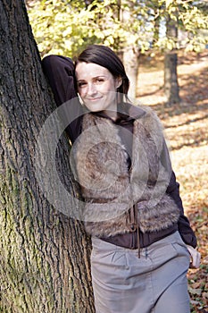 Autumn woman leaning tree
