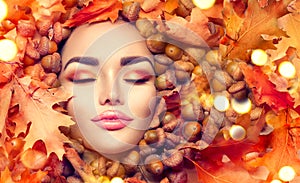 Autumn woman makeup. Beautiful autumn model girl face portrait with bright yellow, red and orange color leaves
