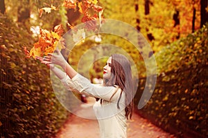 Autumn Woman Outdoors. Woman Fasion Model throwing Up Fal