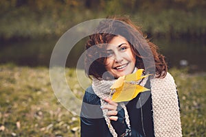 Autumn woman with yellow fall leaf in park