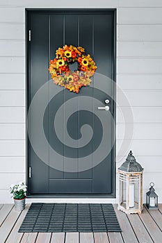 Autumn wreath with sunflowers, pumpkins and maple leaves on front door