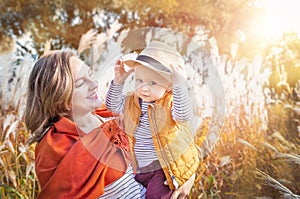 Autumn. Young mother and baby boy (child, kid) having fun outdoors on the fall city park.