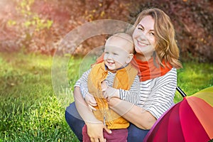 Autumn. Young mother and little baby boy (child, kid) having fun outdoors on the fall park.