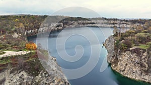 Autumn at Zakrzowek Quarry in Krakow, Aerial view of the serene Zakrzowek Quarry surrounded by autumn-colored trees with