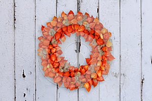 Autumnal Decoration Wreath with Physalis and Withywind on grunge background