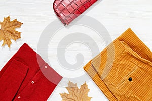 Autumnal Flat lay with warm female clothes. Bright corduroy trousers, red pullover and small bag