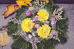 Autumnal floral decoration on grave during All Saints Day in the cemetery