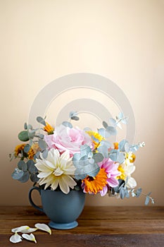 Autumnal flowers bouquet in a vase. Fresh ahlia, roses and eucalyptus plant
