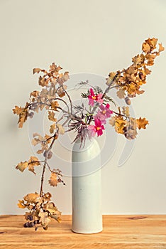 Autumnal ikebana japanese flower arrangement with oak tree branches and orchid